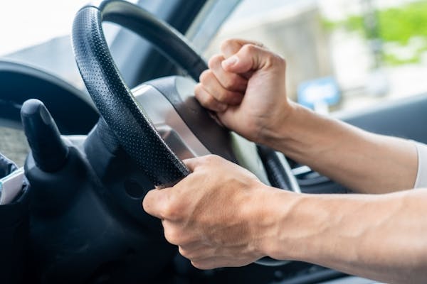 車のクラクションに拳を叩きつける男性