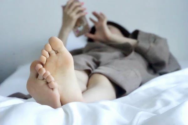 寝ながらスマホを見ている人