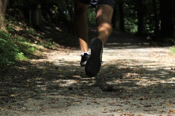 森の中をジョギングしている男性の足アップ