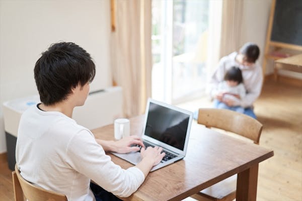 キッチンでパソコン操作をする男性