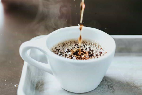 カップにコーヒーを注いでいるところ