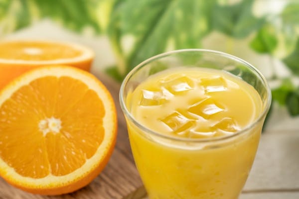 オレンジジュースとカットしたオレンジ