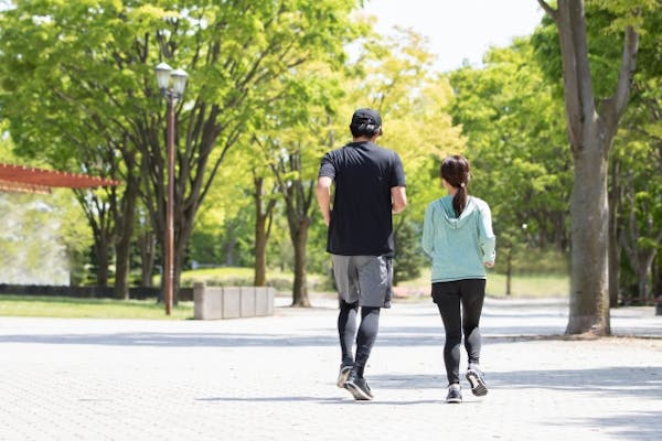 並んでウォーキングしている男女の後ろ姿