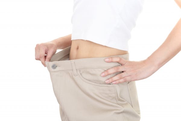 ウェストに余裕のあるパンツを見せる女性