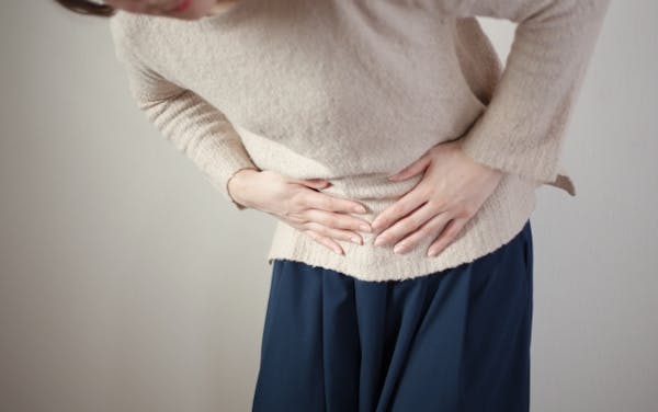 お腹をおさえている女性