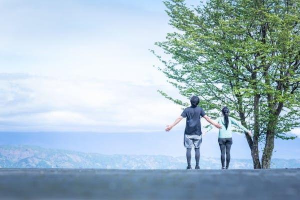 景観の良い場所で並んで深呼吸している男女