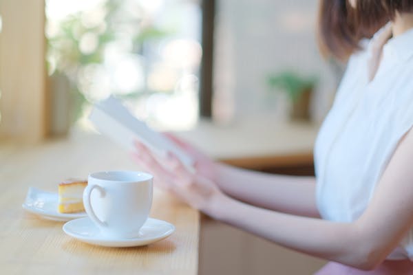 コーヒーとケーキを用意して読書する人