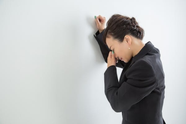 めまいがしているスーツの女性