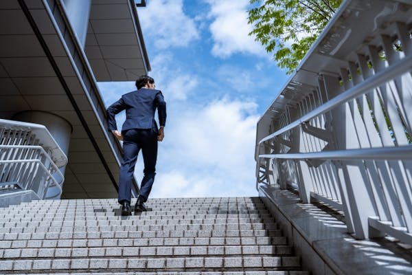 階段をのぼるスーツの男性