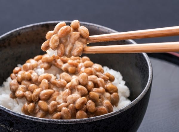 ご飯のうえにのせた納豆を箸ですくったところ