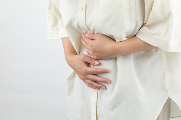 腰をかがめてお腹をおさえている人