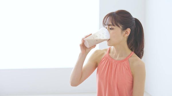 プロテインを飲んでいる女性