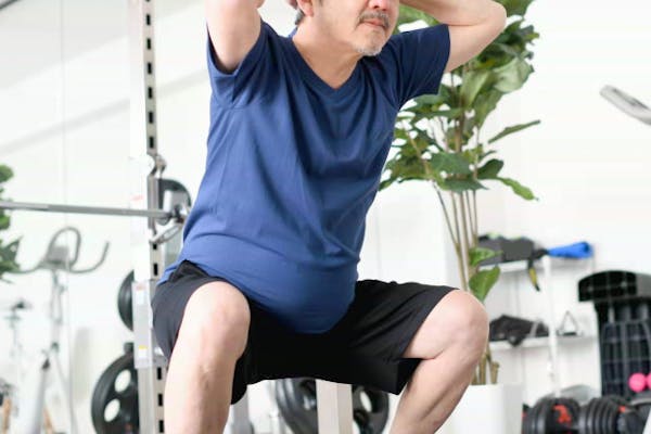 スクワットする中年男性
