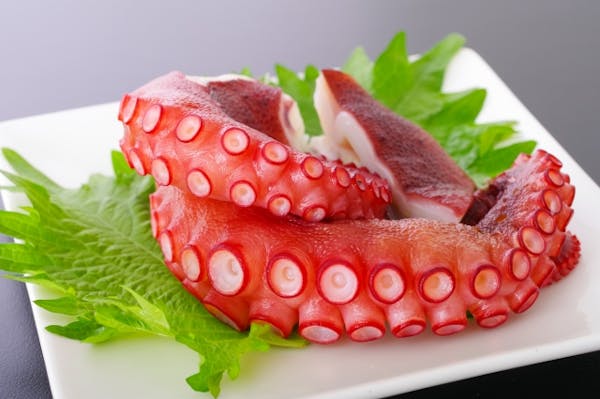 お皿にのせた茹でたタコ