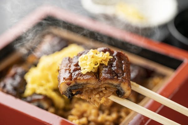 うな重をお箸で持ち上げているところ