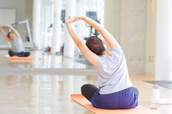 鏡の前でストレッチをする女性