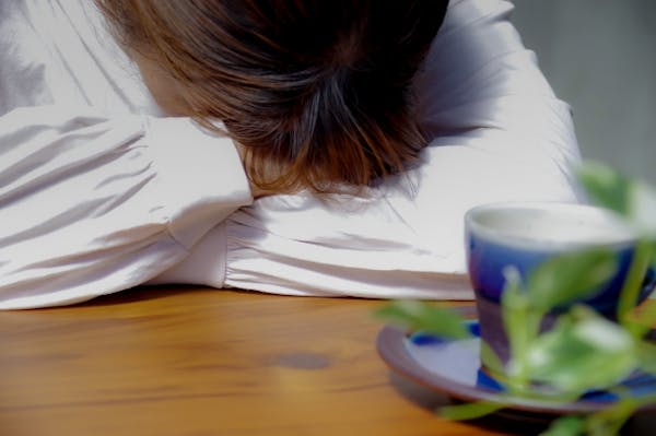 テーブルに突っ伏している女性