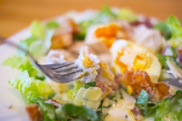 ミモザサラダをフォークで食べているところ