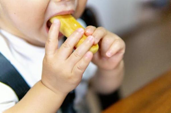 おやつを食べている幼児
