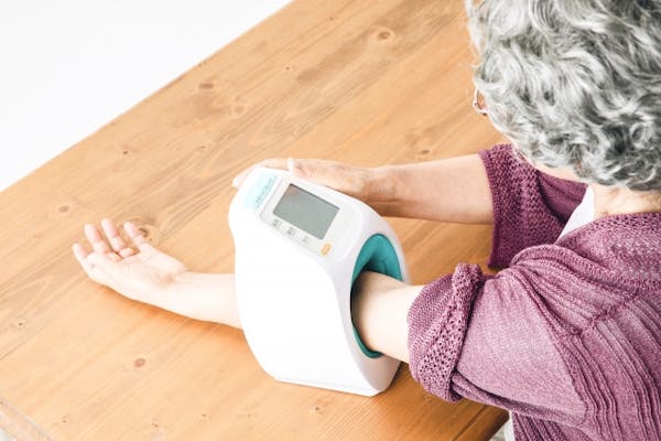 自宅で血圧を測定する高齢女性