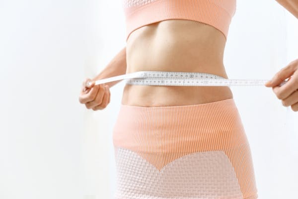 メジャーでウエストを計測している女性