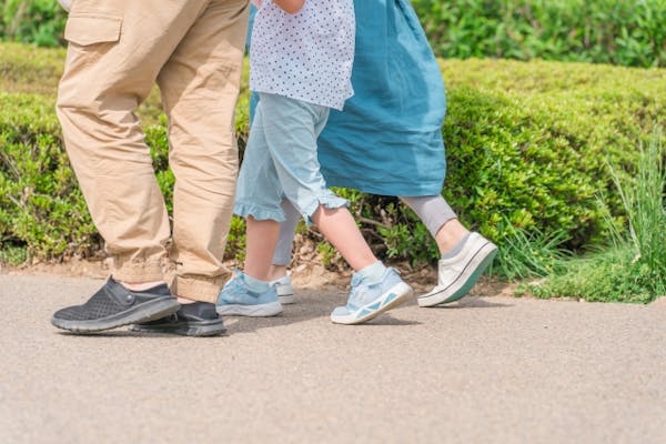 並んで歩く核家族の足