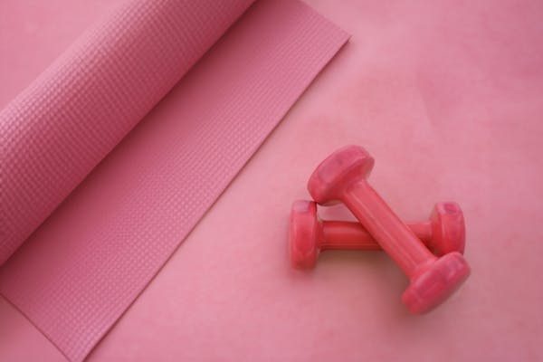 ピンクのトレーニングマットとダンベル