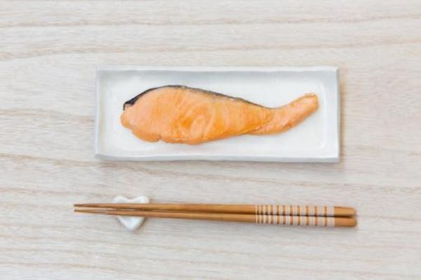 お皿にのった焼き鮭と箸