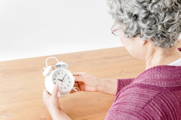 時計をみる高齢女性