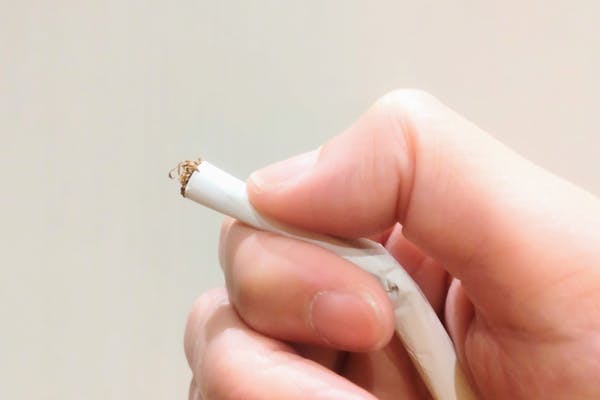 紙タバコを指でつぶしているところ