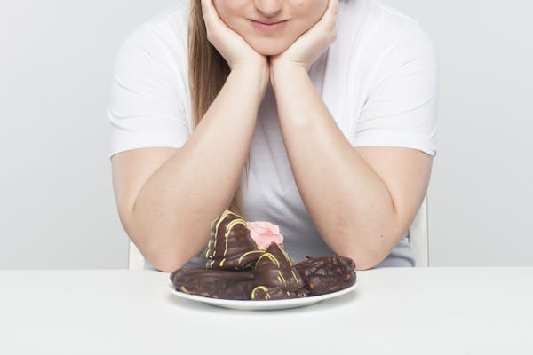 チョコレートデザートを前に悩む女性