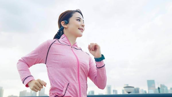 ピンクの服を着てジョギングする女性