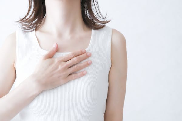 自分の胸に手をあてている女性
