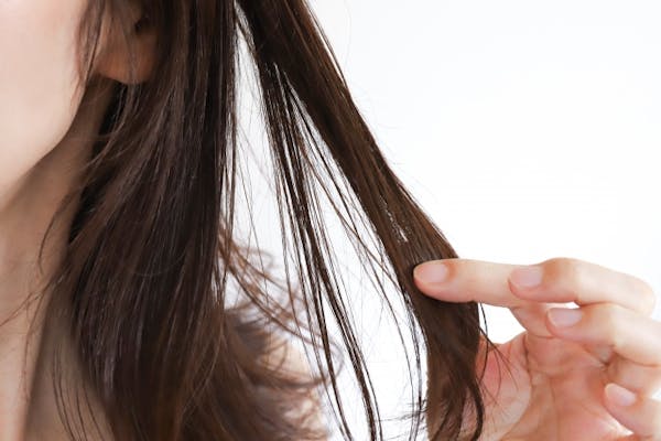 自分の髪の毛をひっぱる女性