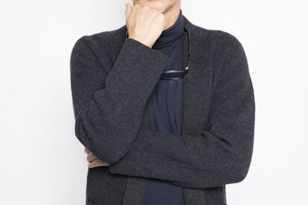 腕を組んで考えている様子の男性
