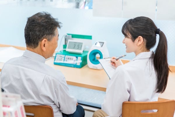 血圧計の目前で話しをする患者と看護師