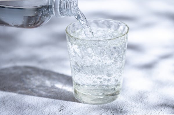 ボトルからグラスに水を注いでいるところ