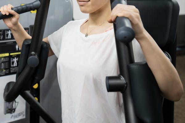 チェストプレスで筋トレをする女性