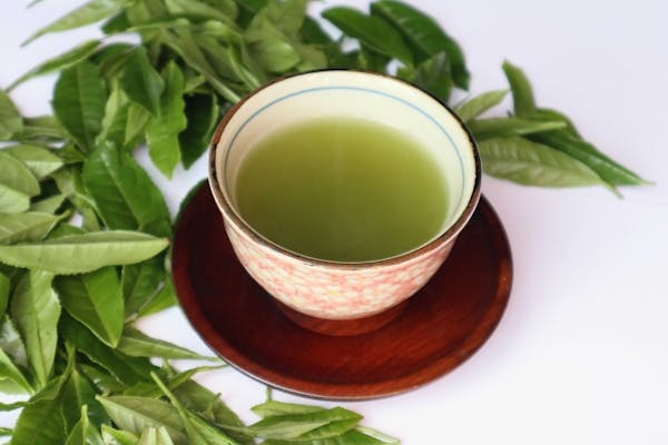 お茶の葉と湯呑に注がれた緑茶