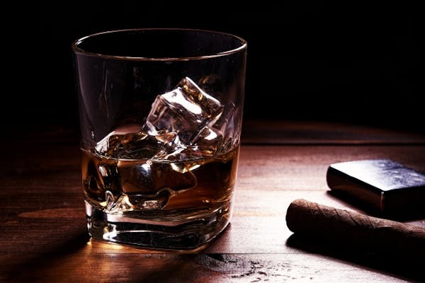 グラスにはいったお酒と葉巻