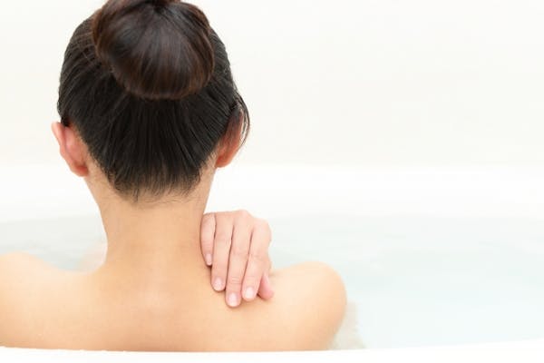 湯船につかっておる女性の後ろ姿