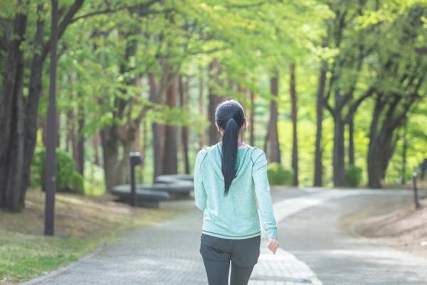 公園をウォーキングしている女性の後ろ姿