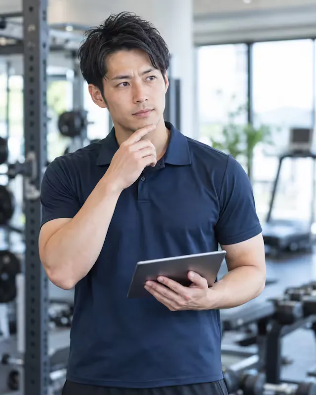 ジムの運営について考えるトレーナー社員のイメージ